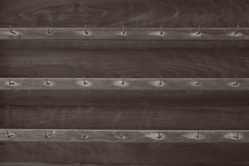 a close up of a wooden shelf with hooks