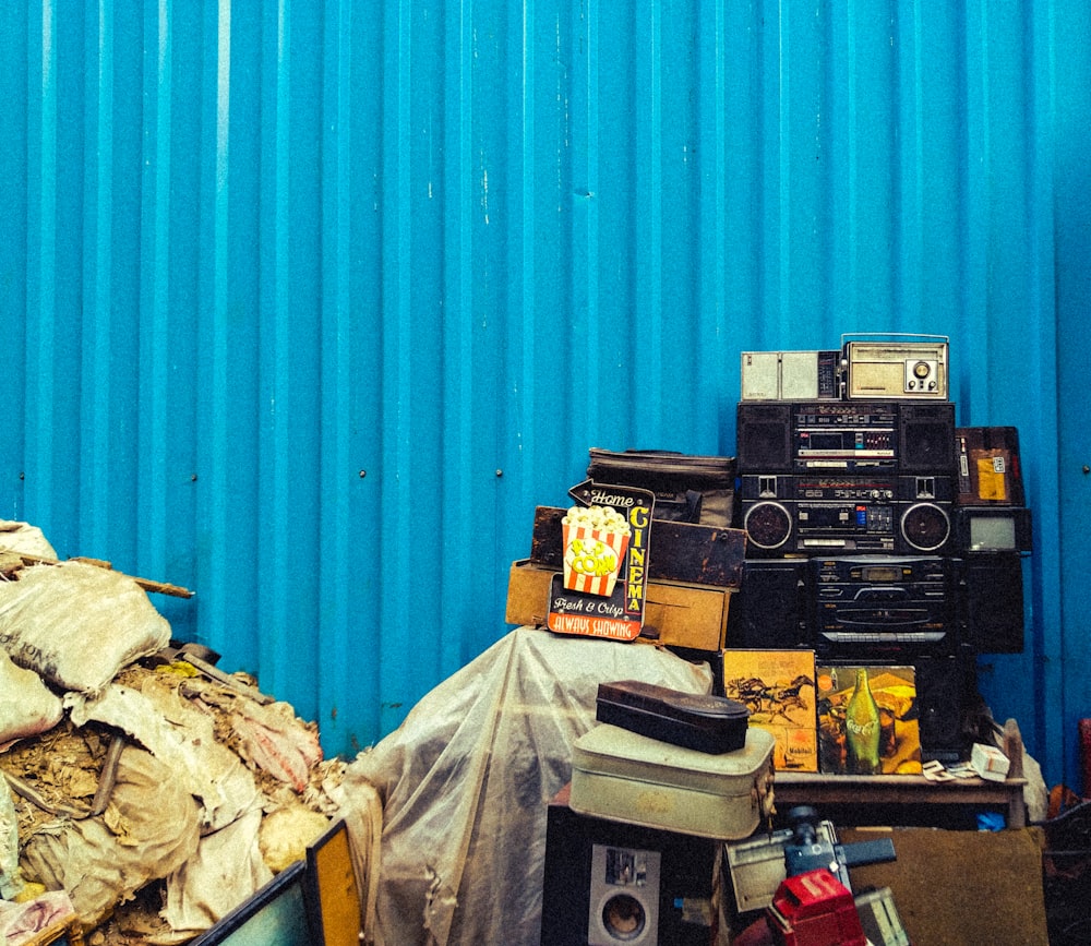 a pile of junk sitting next to a blue wall