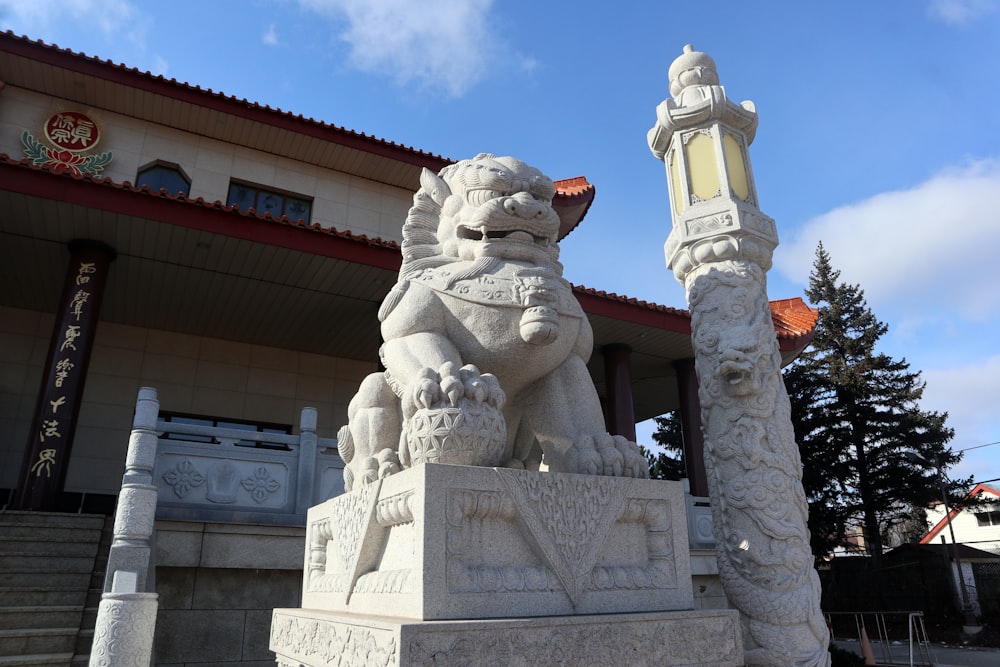 a stone lion statue in front of a building