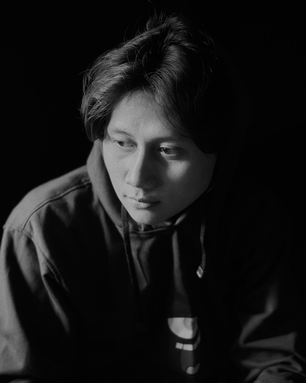 a black and white photo of a person in a hoodie