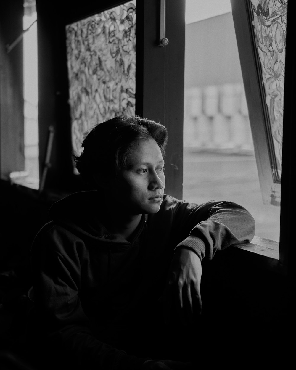 a man looking out a window at the street