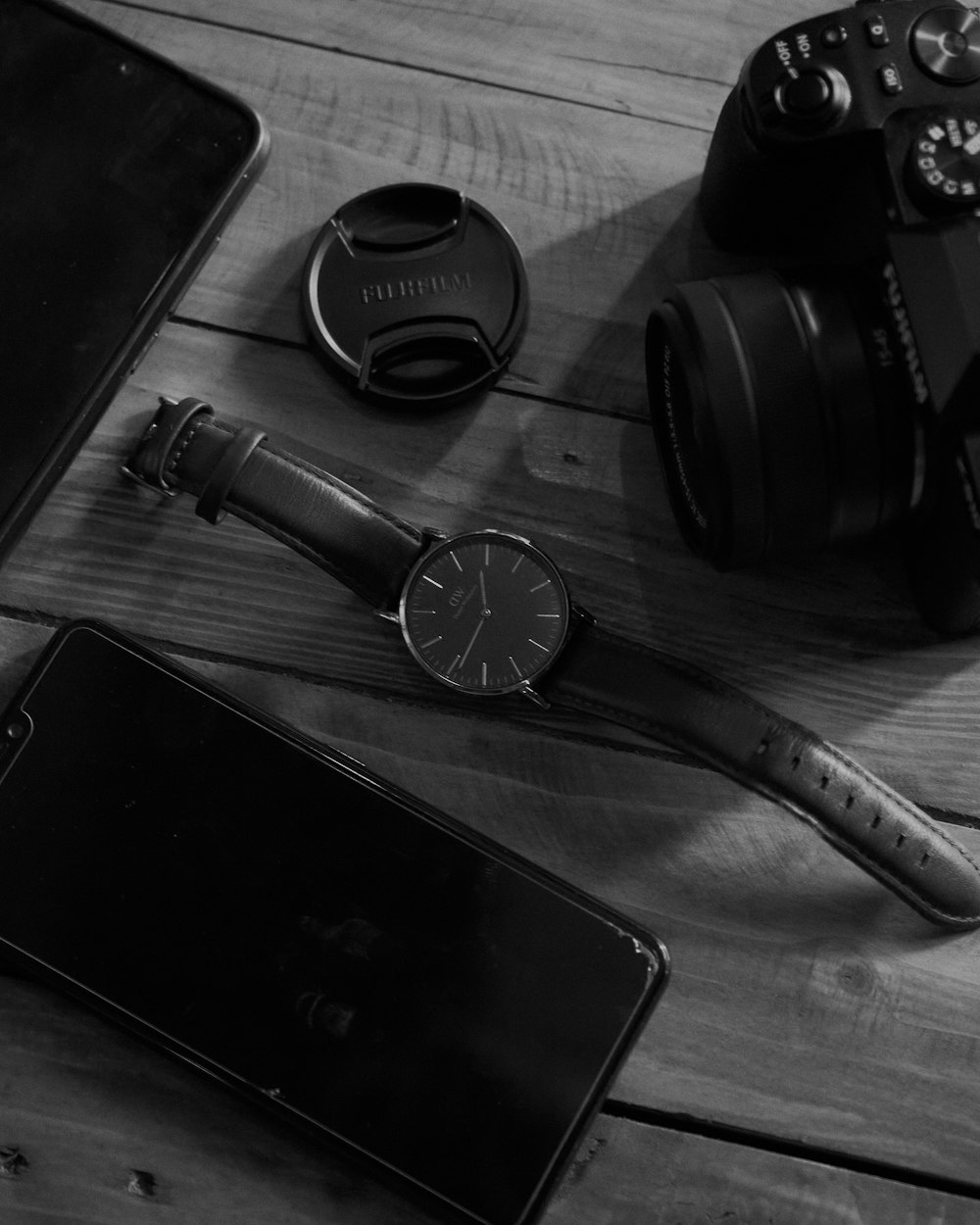 a black and white photo of a camera and a cell phone