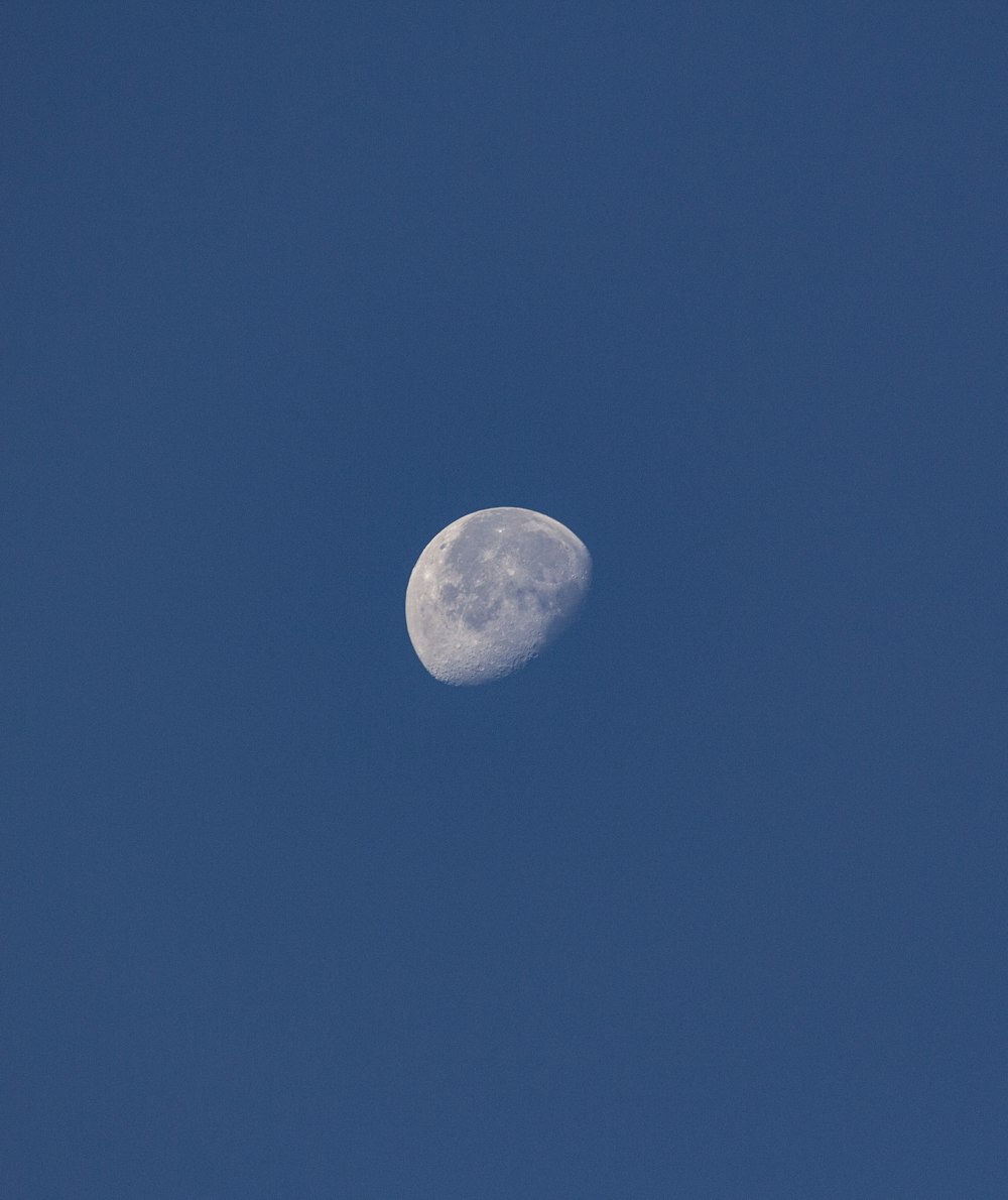 a half moon in a clear blue sky