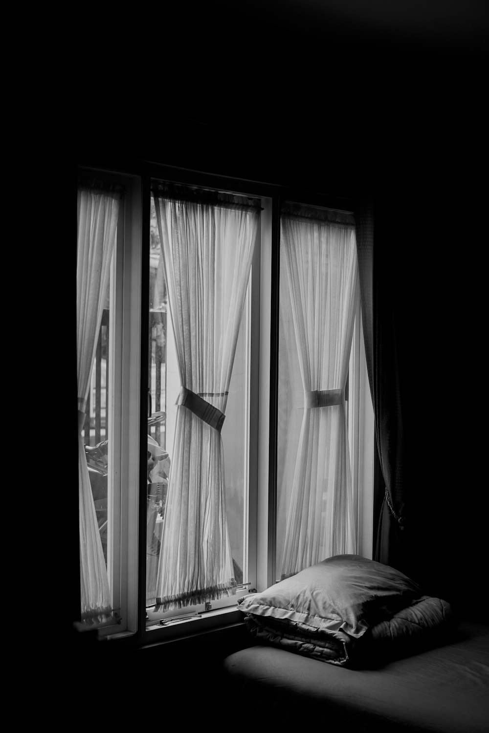 a black and white photo of a bed in a dark room
