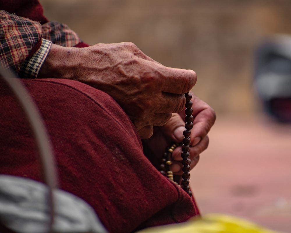 a person holding a rosary in their hands