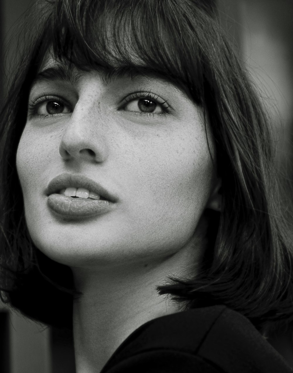 a black and white photo of a woman with bangs