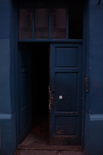 a blue door is open on a blue building