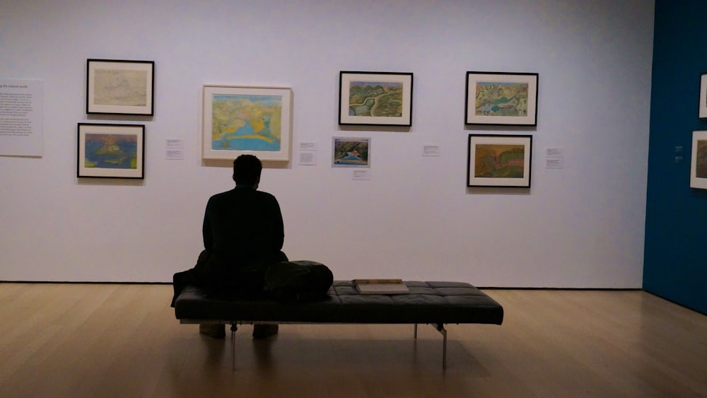 a person sitting on a bench in a museum