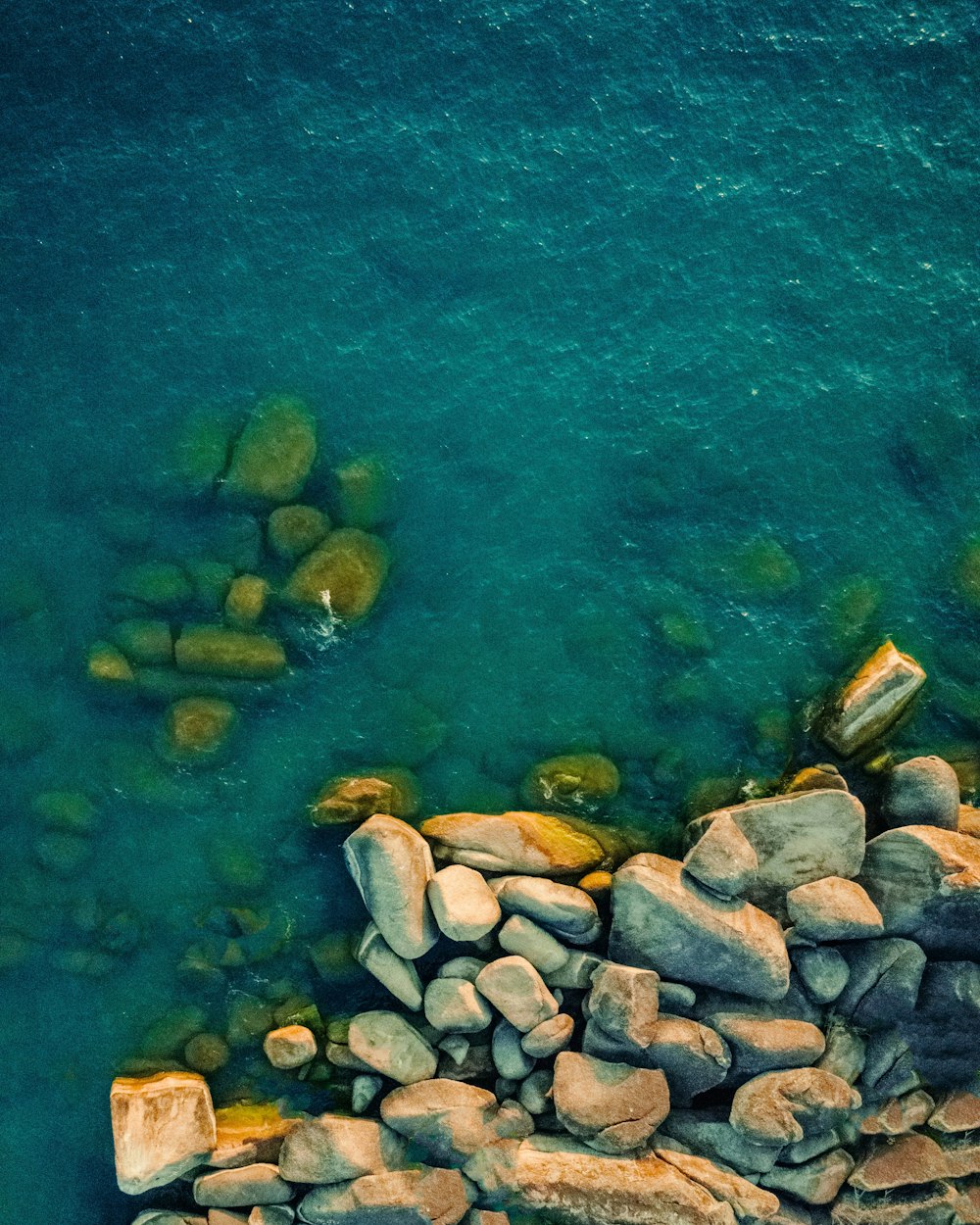 an aerial view of rocks and a body of water