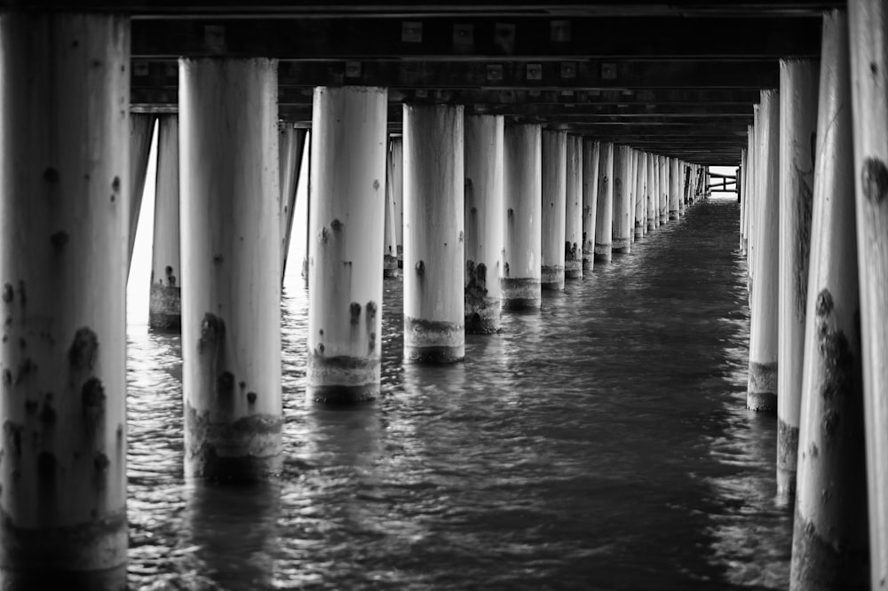 a black and white photo of the underside of a pier
