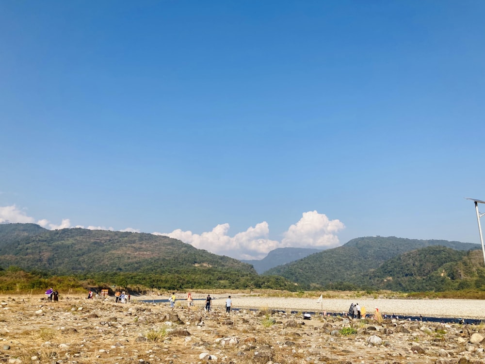 a group of people standing on top of a dirt field