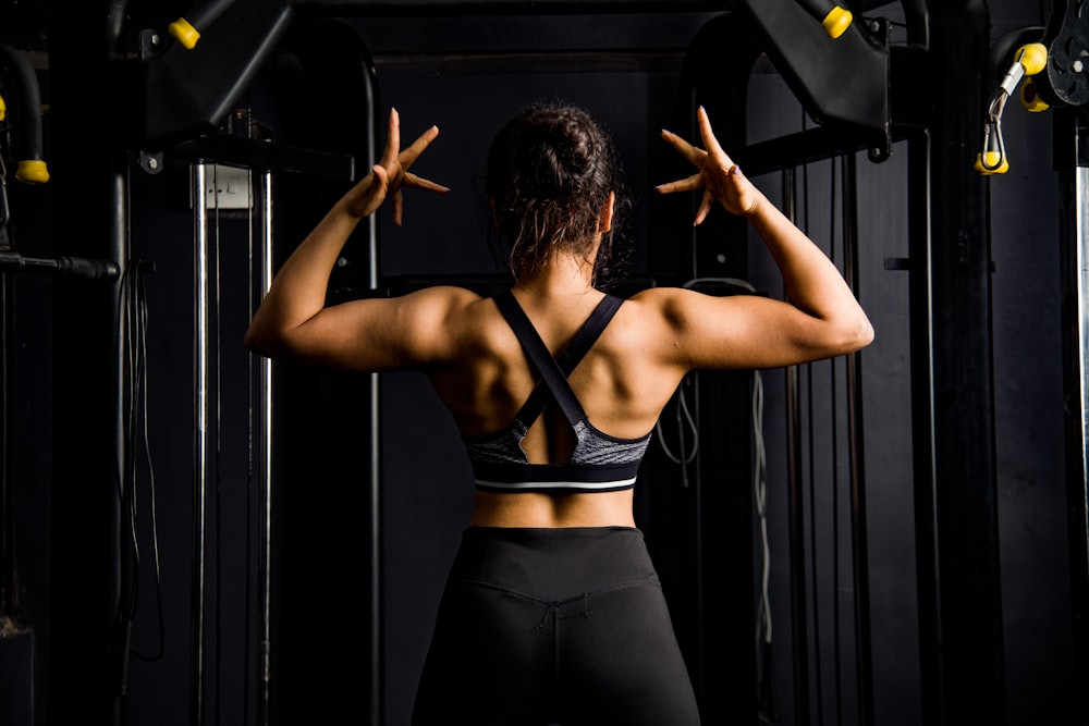 a woman standing in a gym with her back to the camera