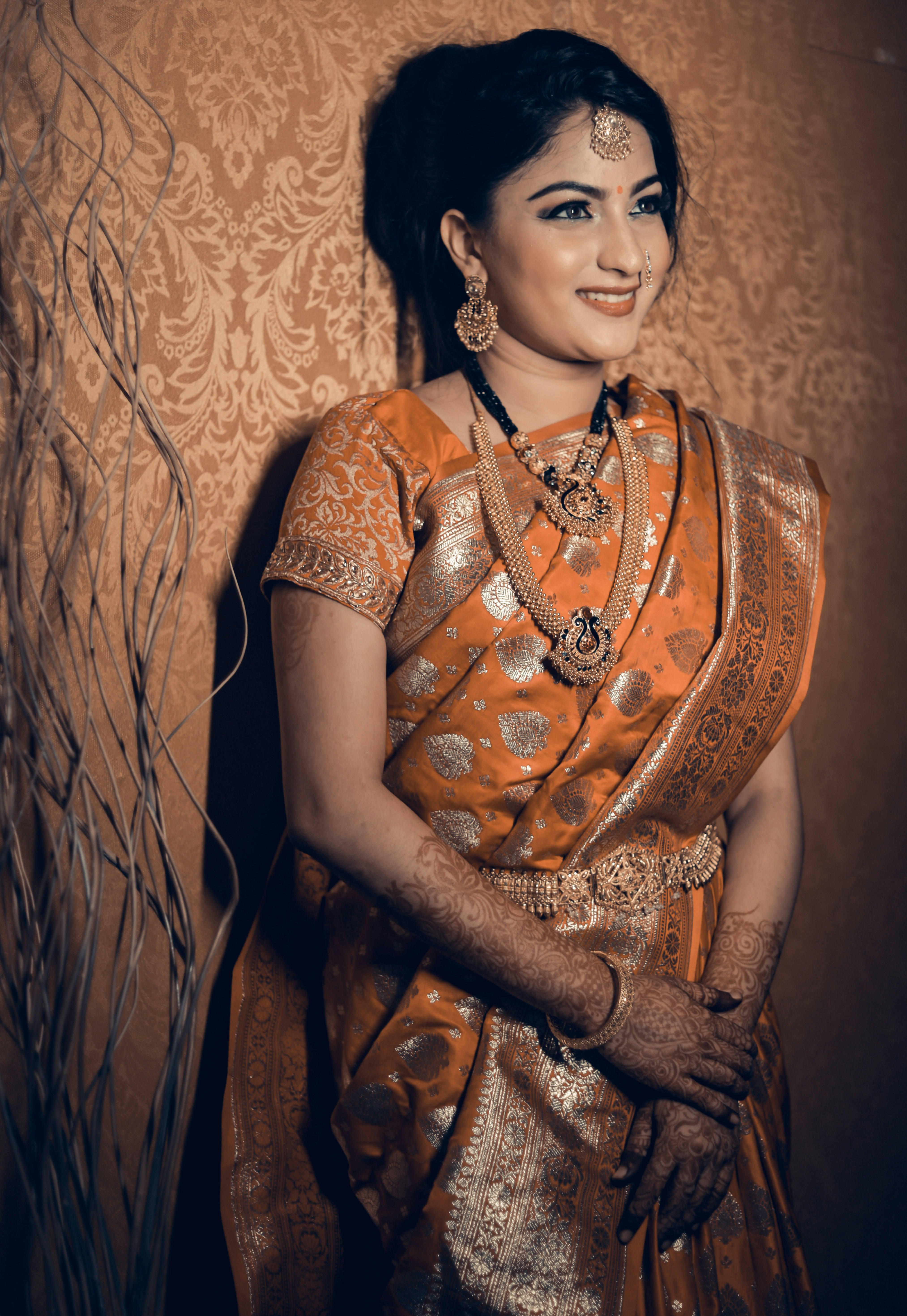 Una mujer en un sari naranja y dorado