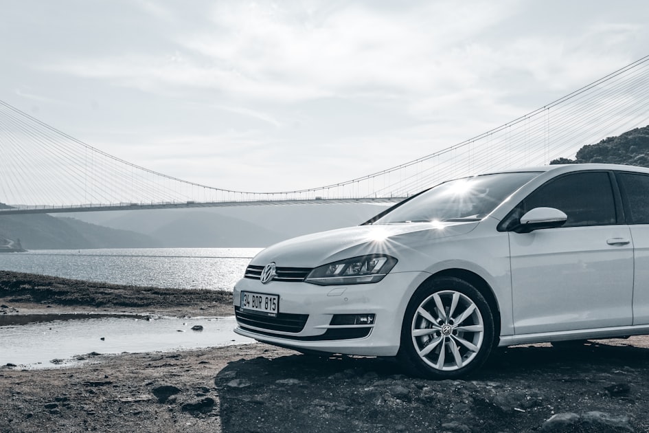 a white car parked on a rocky beach