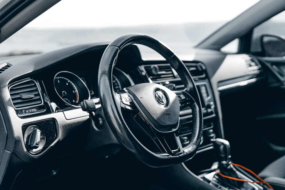 the interior of a car with a steering wheel and dashboard