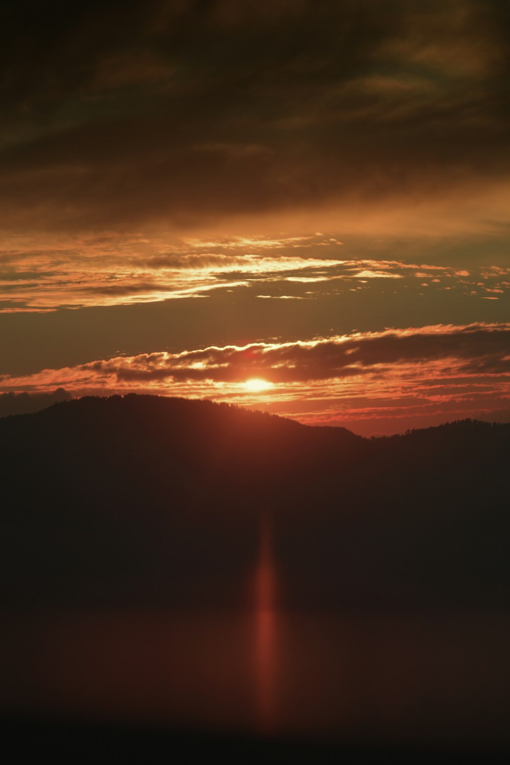 the sun is setting over a mountain range