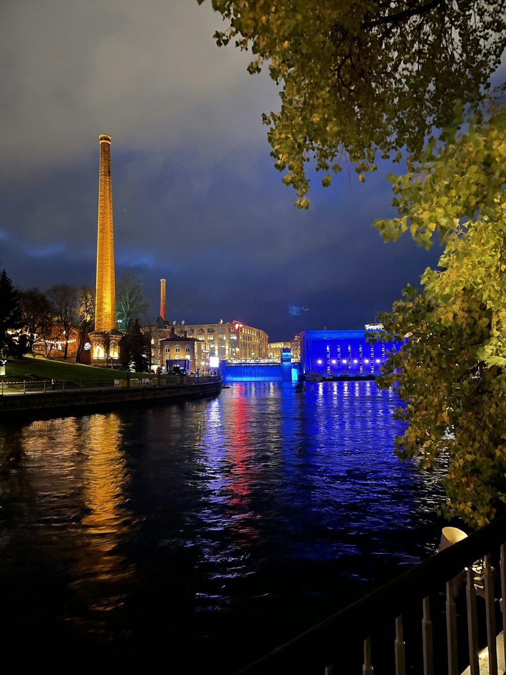 a view of a river at night with a tower in the background