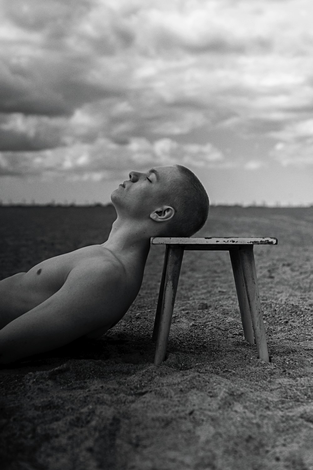 a man laying on top of a wooden bench