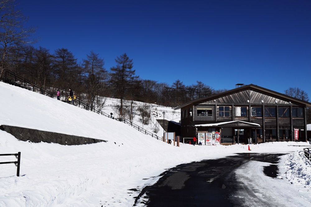 a snow covered road with a building on the side of it