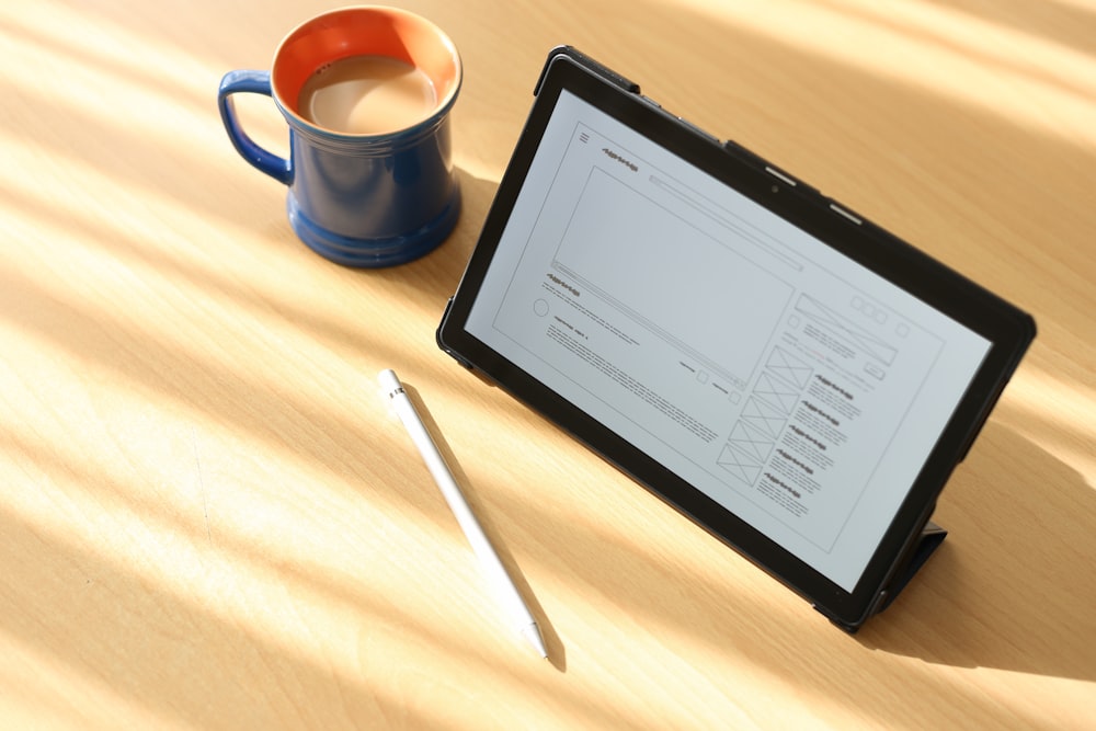 a tablet and a cup of coffee on a table