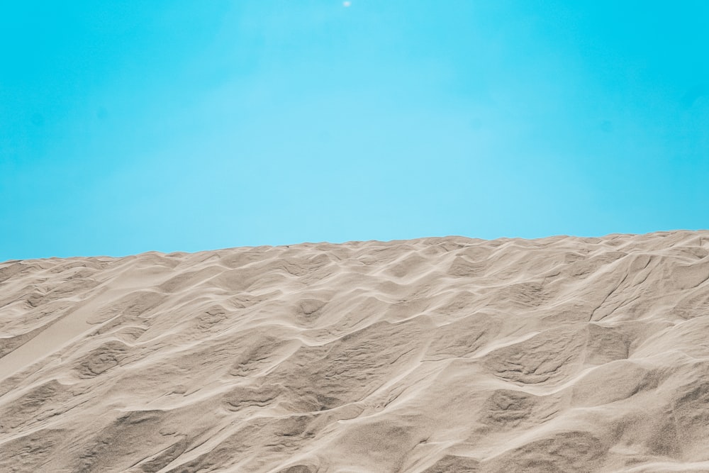 a person standing on top of a sandy hill