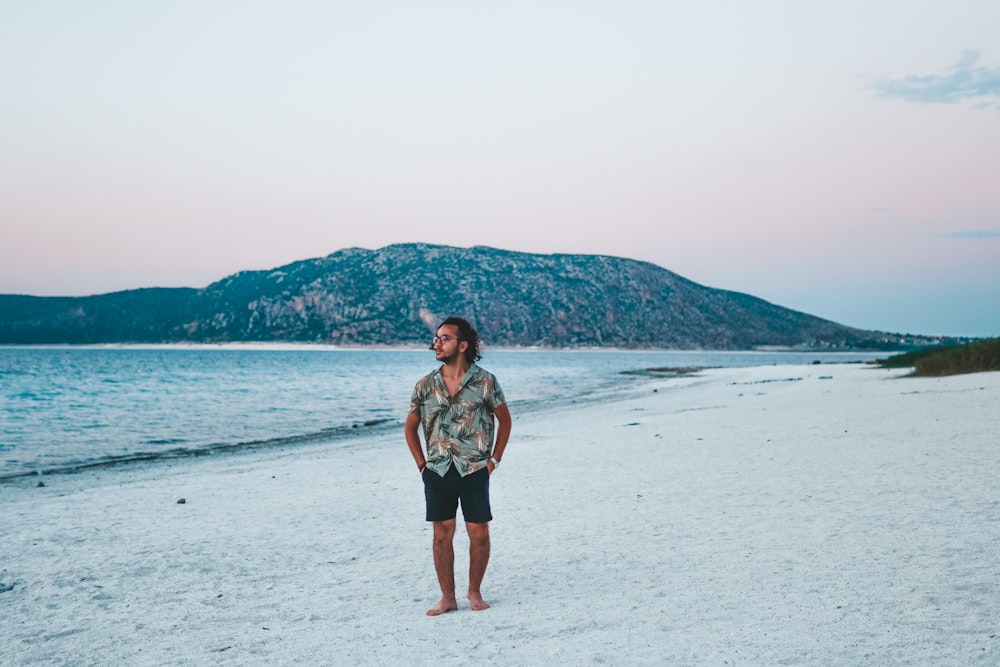 um homem de pé em uma praia ao lado do oceano