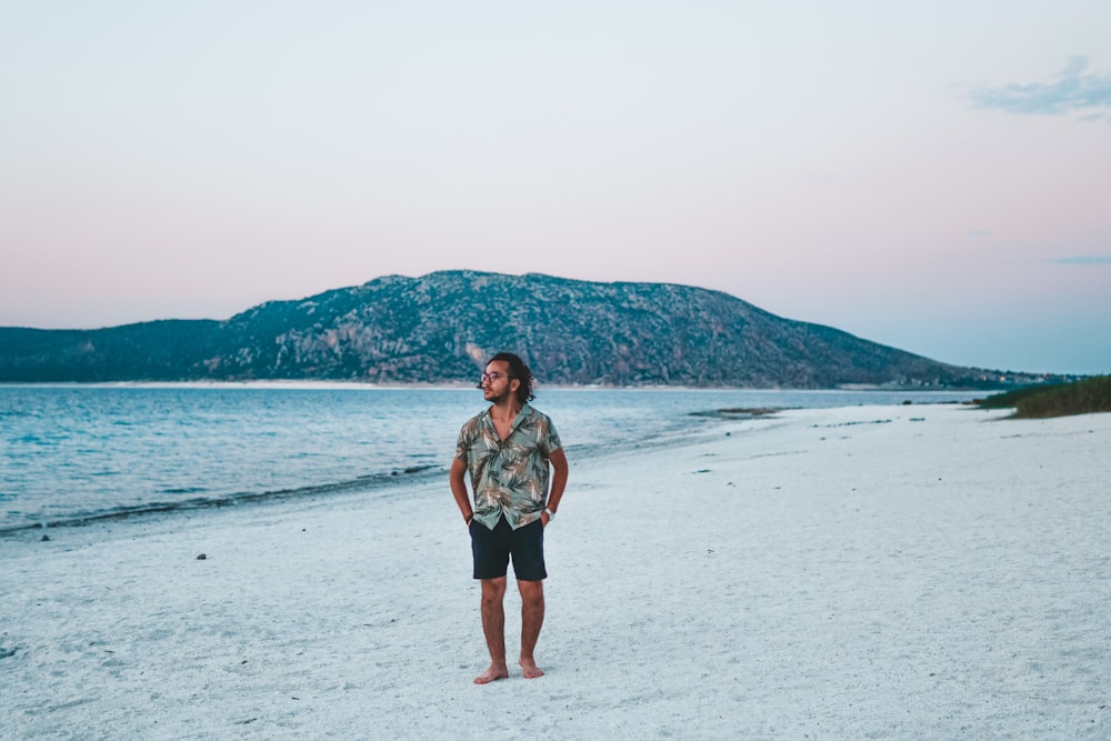 Ein Mann steht an einem Strand am Meer