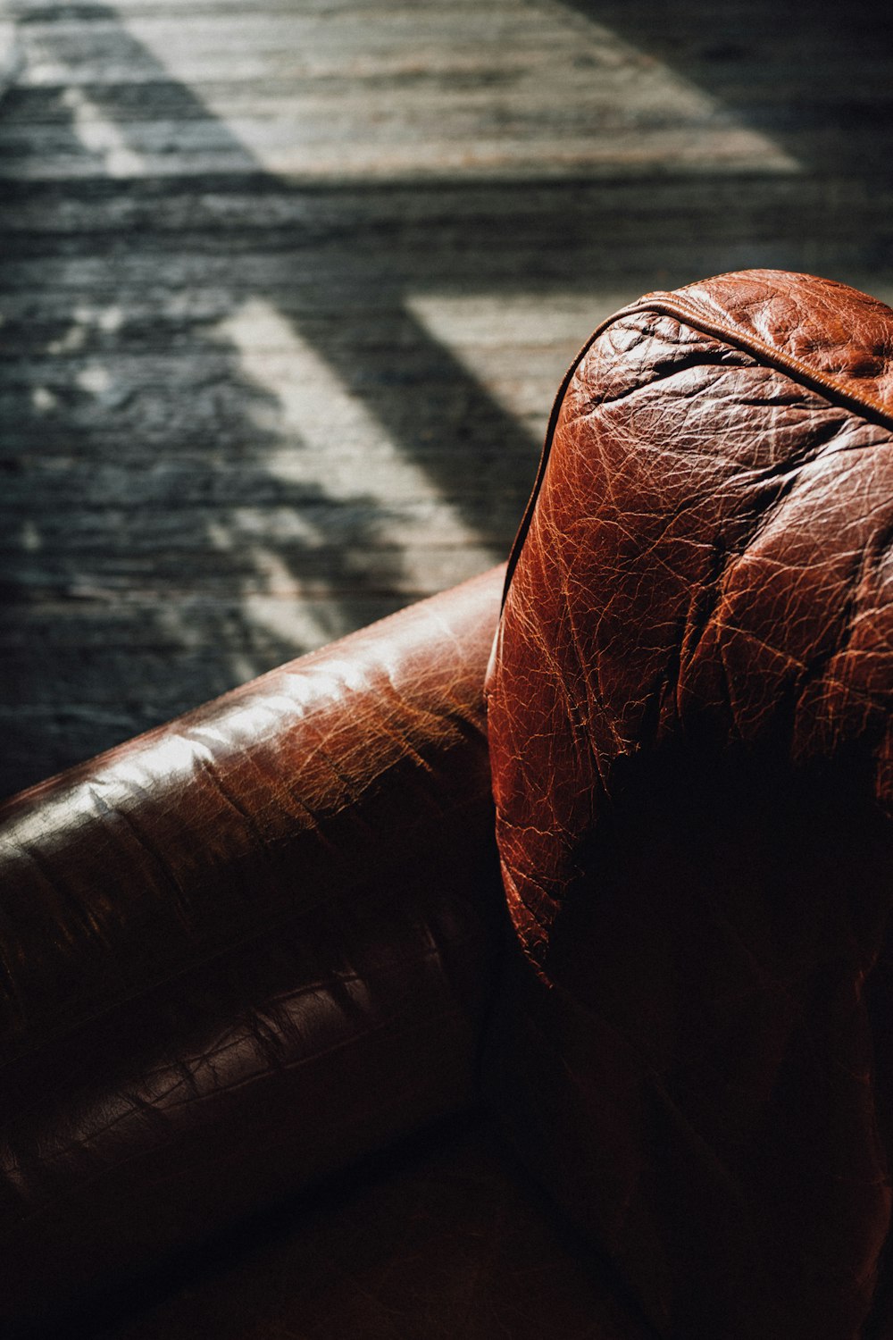 a brown leather couch sitting on top of a wooden floor