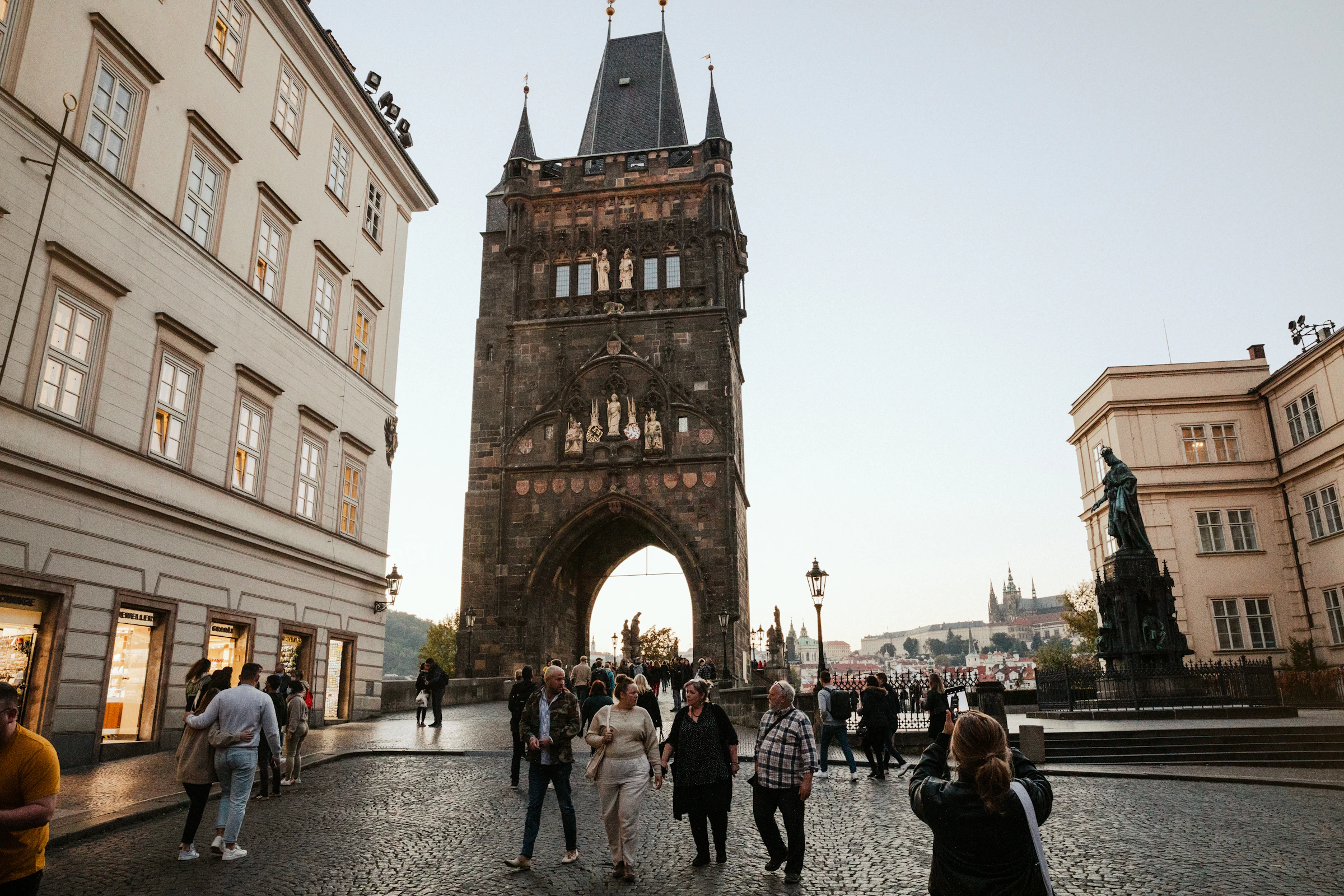 People walking a cobblestone street between historic European buildings