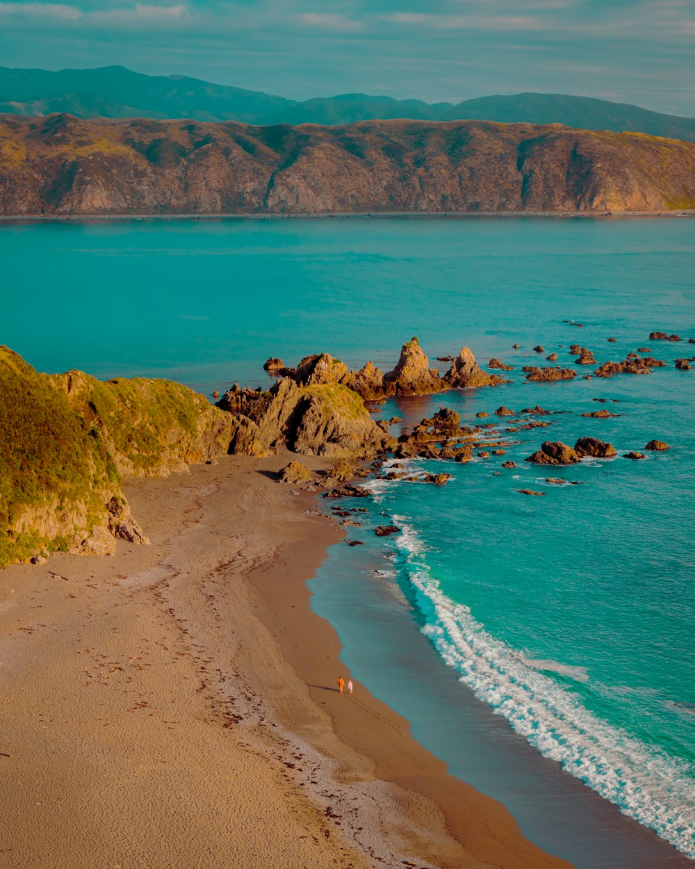 a sandy beach with waves coming in to shore