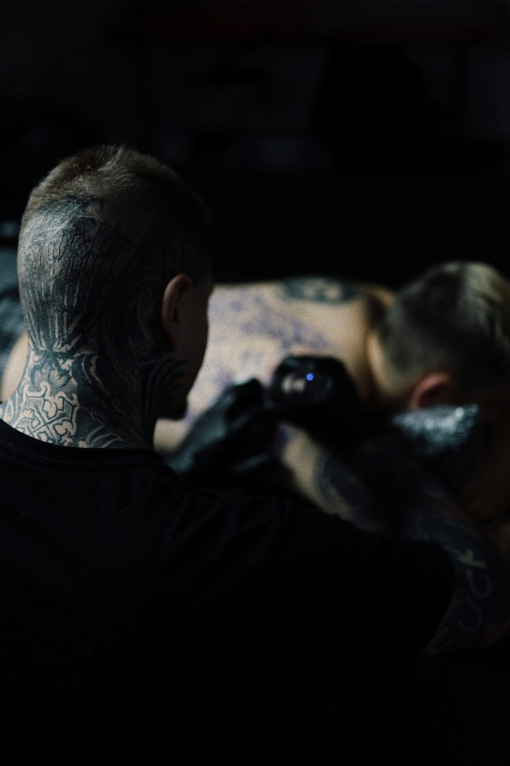 a tattooed man taking a picture with a camera