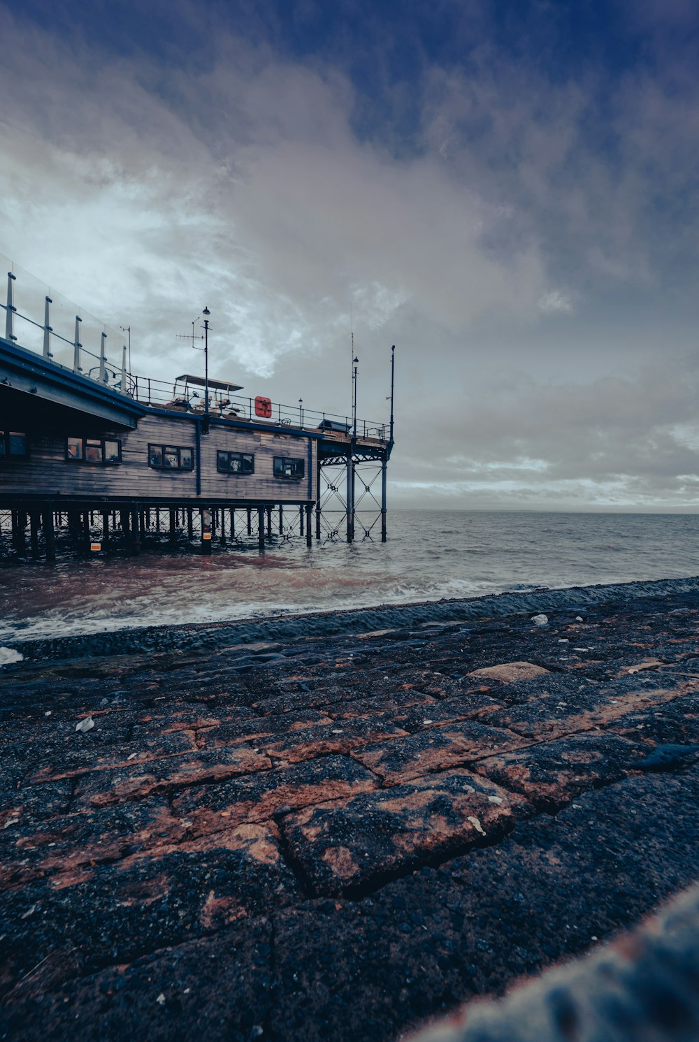 a pier on the ocean with a cloudy sky