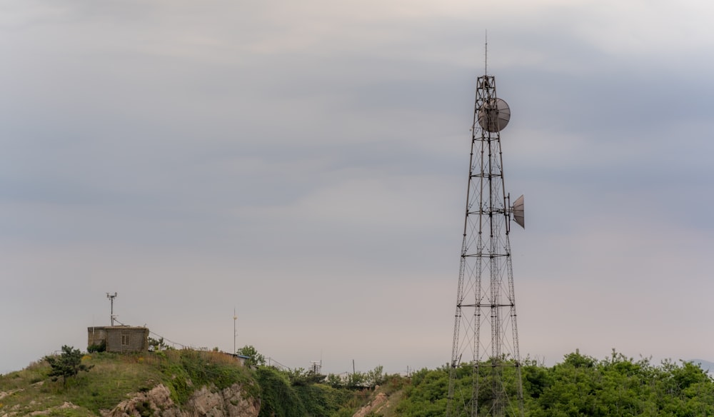 a tower with a wind indicator on top of a hill