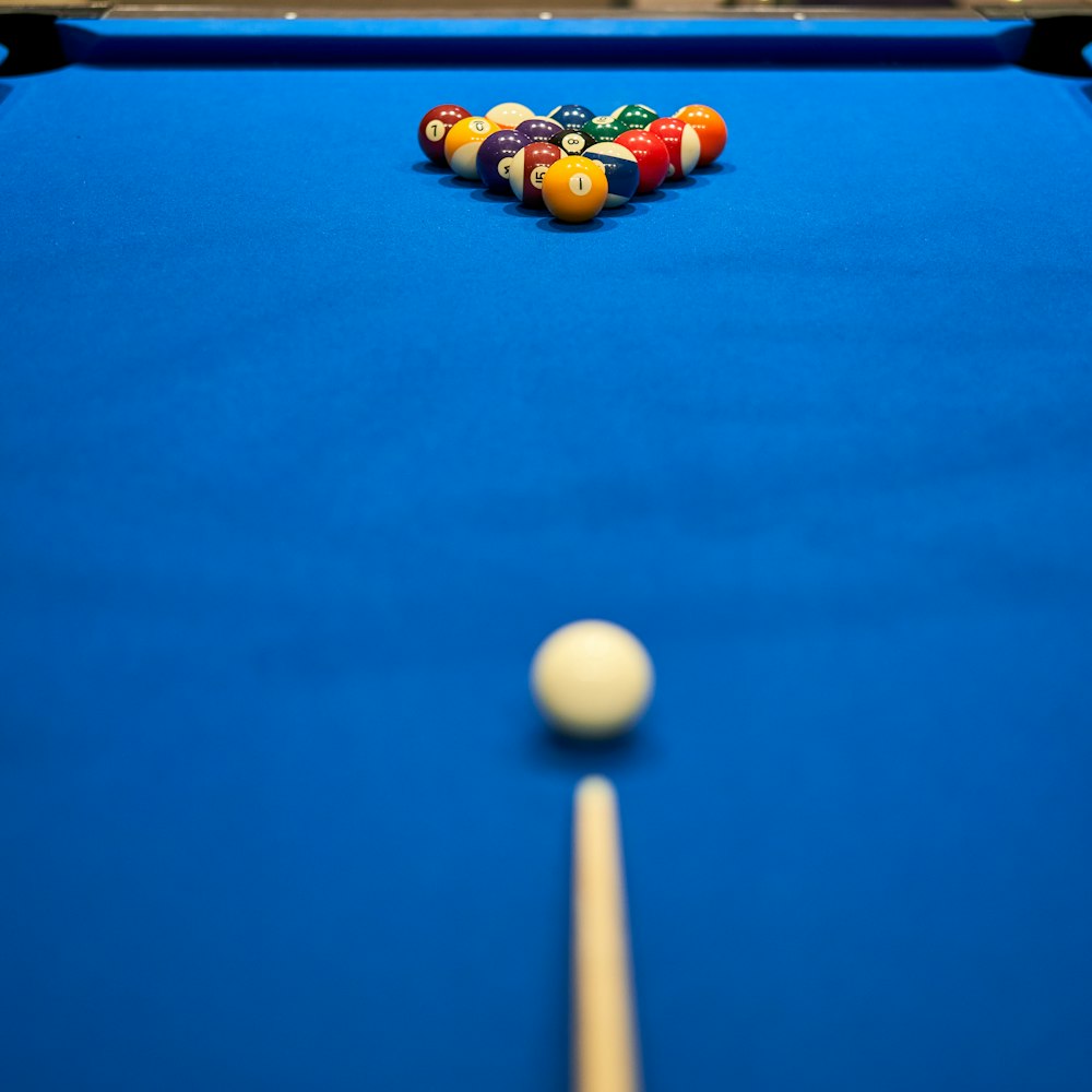 a pool table with a pool ball and cues