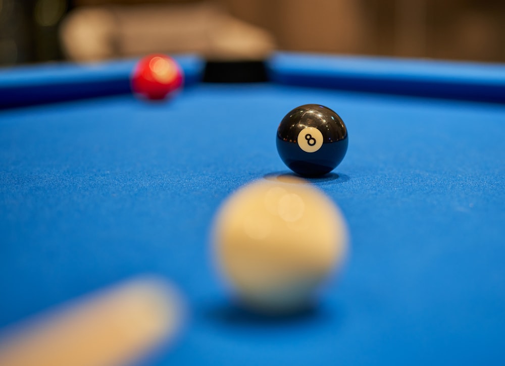 a pool table with a pool ball and cues