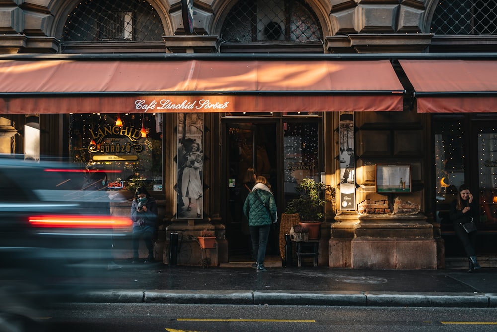 a group of people standing outside of a store