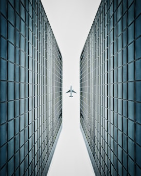 an airplane flying over a tall building in the sky