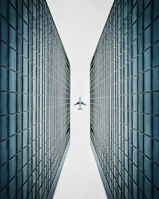 an airplane flying over a tall building in the sky