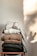 Close-up of a cozy winter jersey draped over a wooden chair in soft natural light.