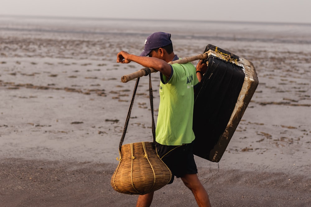 a man carrying a large piece of luggage on a beach