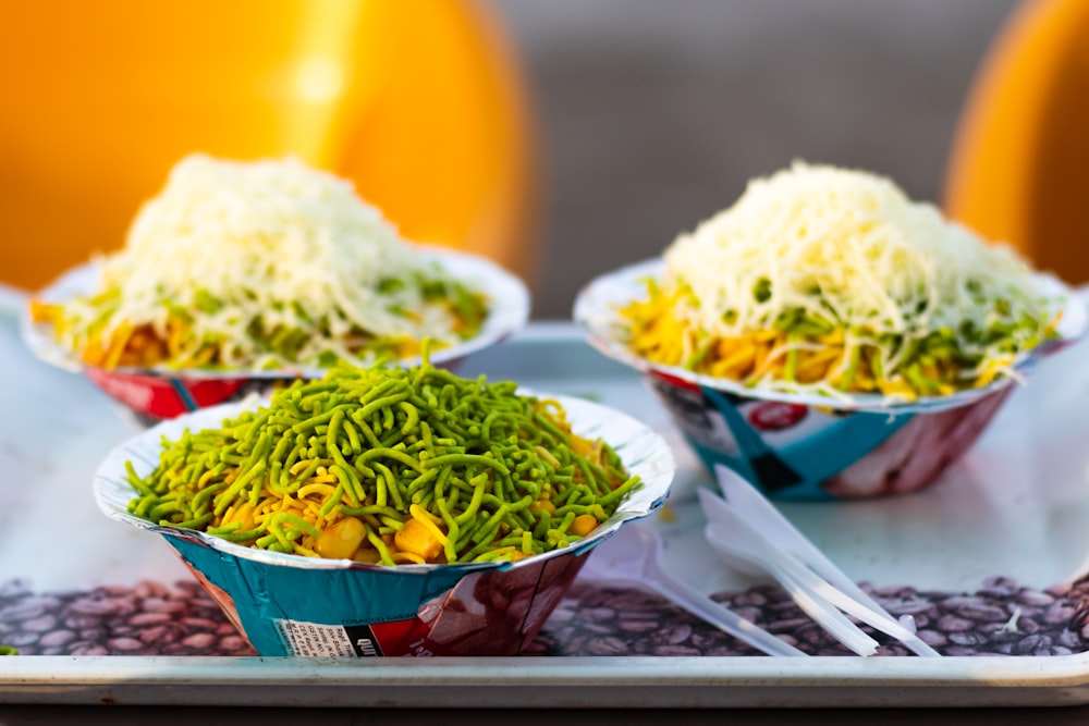 a tray with three bowls of food on it