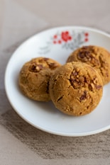 a white plate topped with three cookies on top of a table