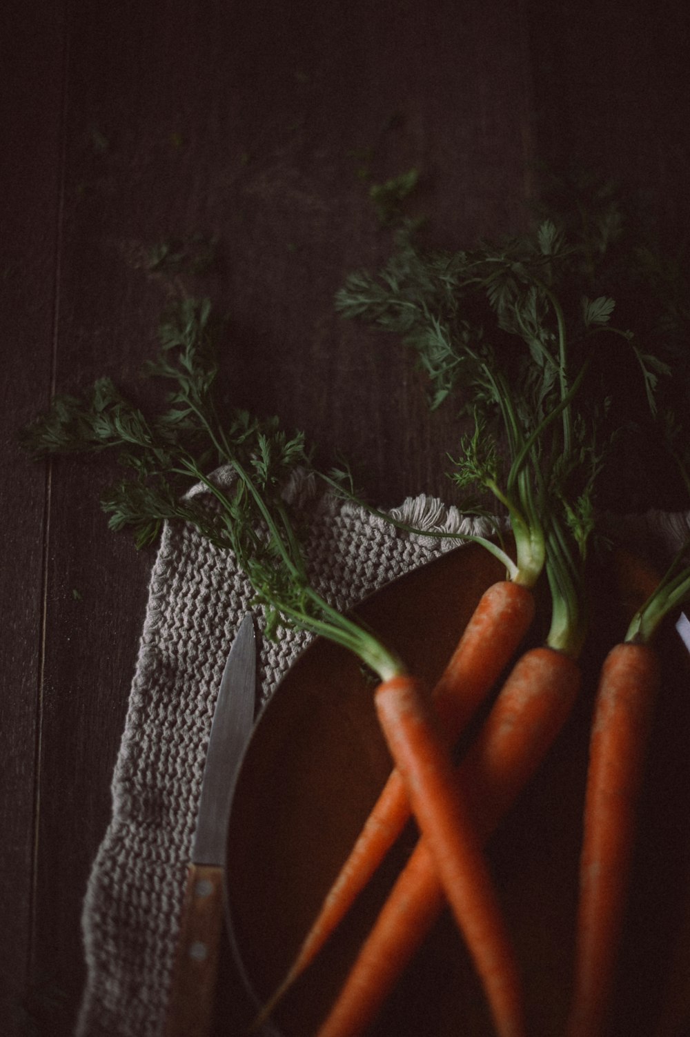 a bunch of carrots sitting on top of a wooden cutting board