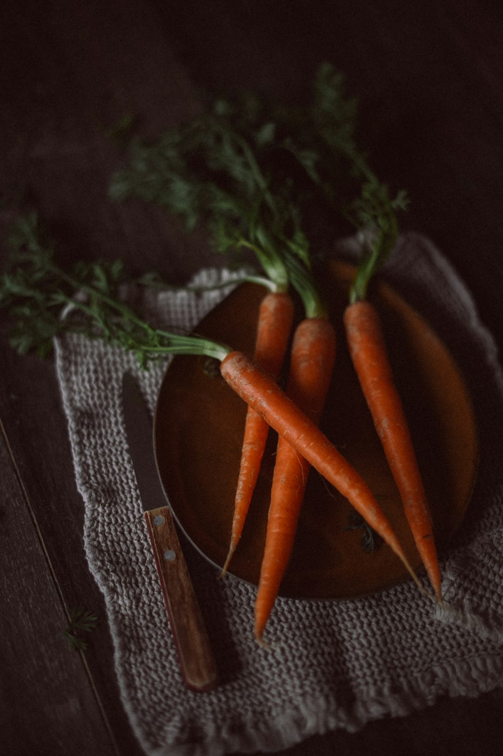 a plate of carrots on a cloth with a knife