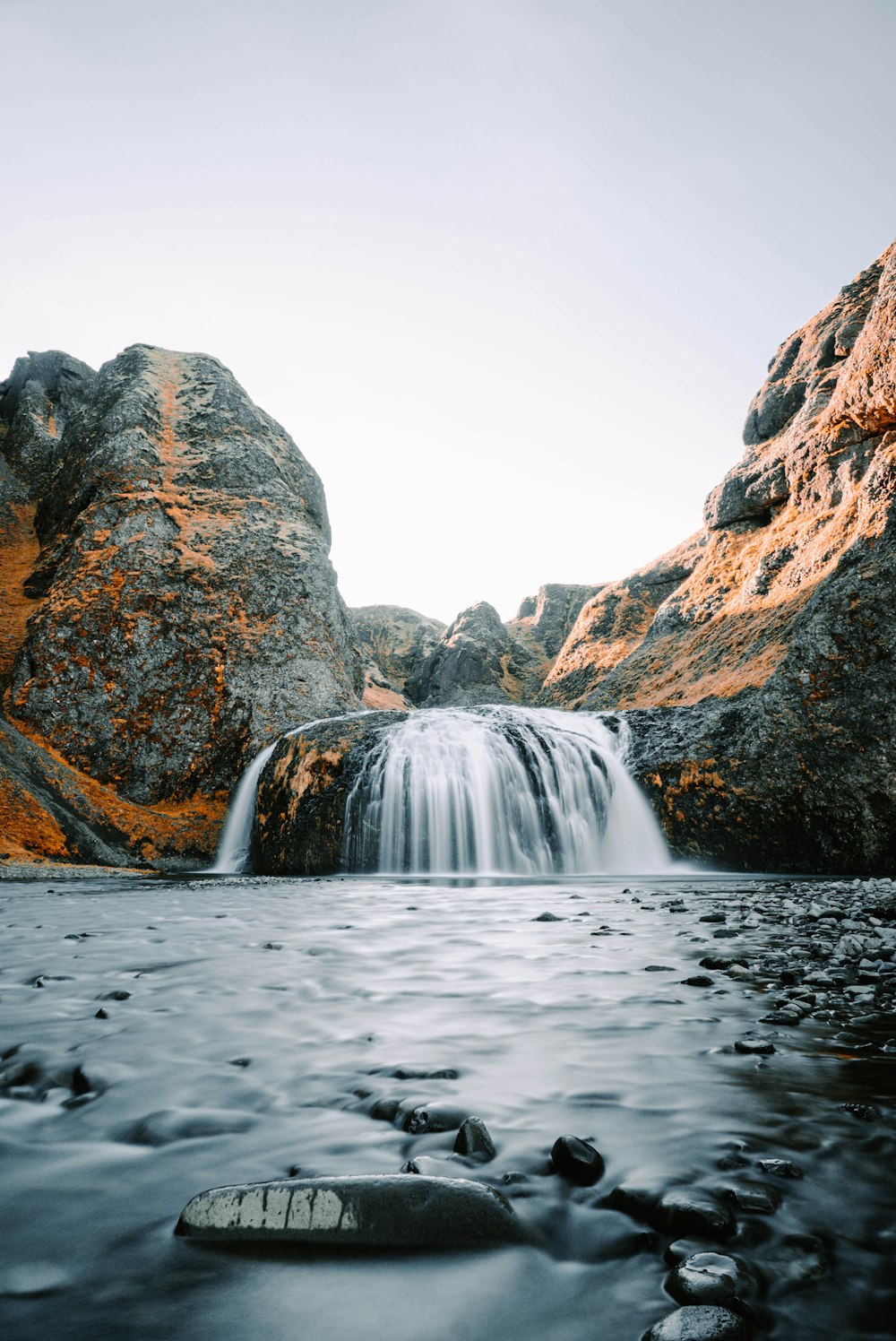 a small waterfall in the middle of a body of water