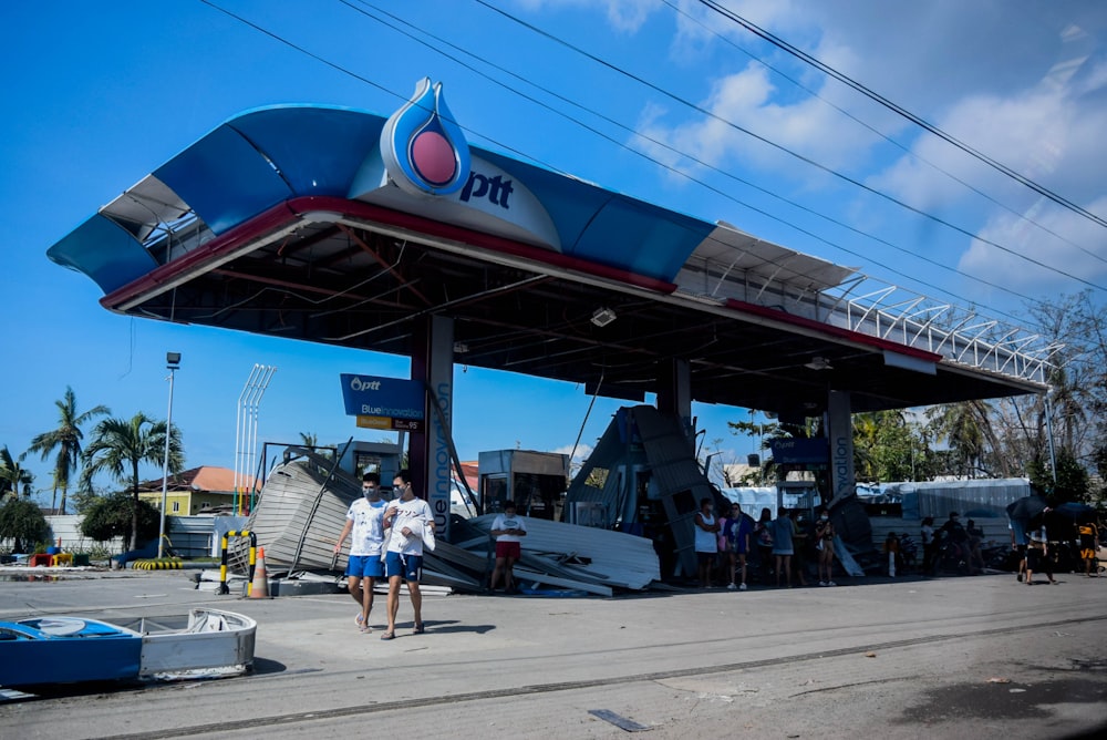 a couple of people that are standing in front of a gas station