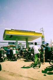 a group of people standing around a gas station