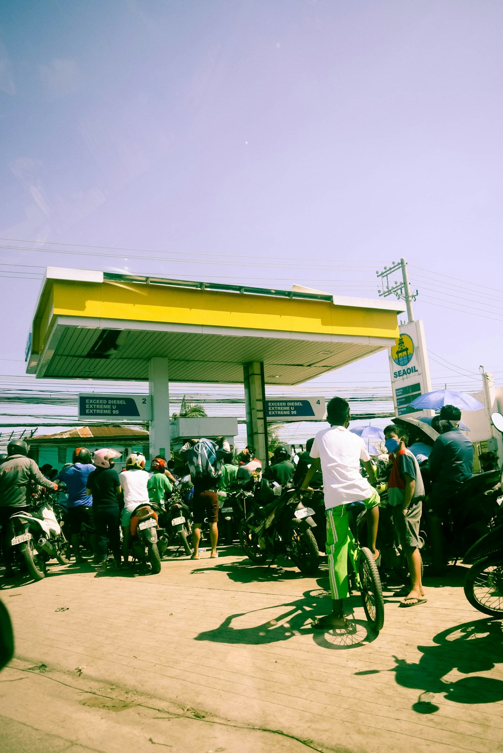 a group of people standing around a gas station