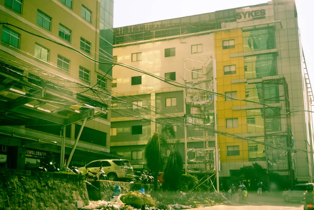 a yellow and green building and some wires and cars