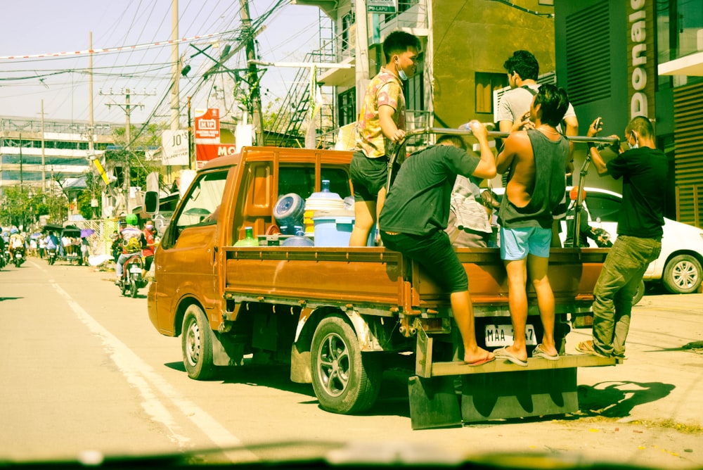 a group of people standing on the back of a truck